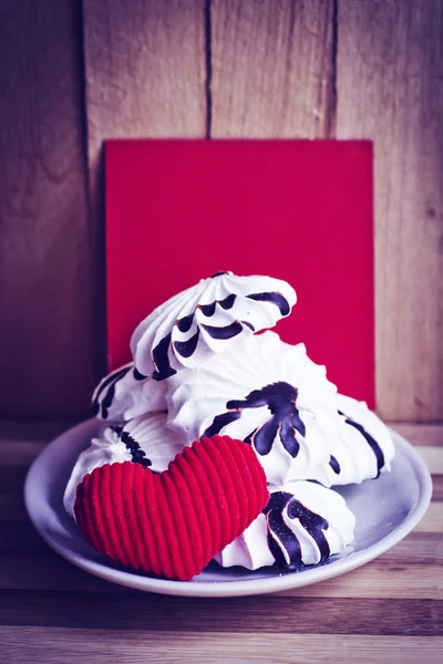 Galletas de merengue y corazón rojo — Foto de Stock