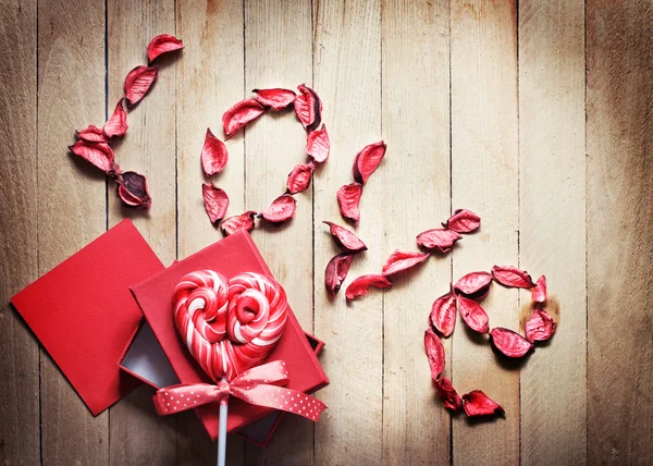 Piruleta en forma de corazón con pétalos y caja de regalo — Foto de Stock