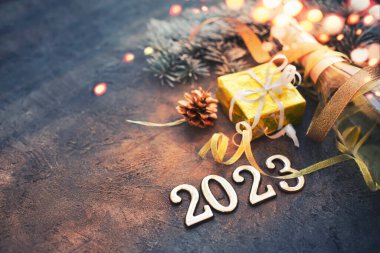 Mutlu yıllar 2023 / arka plan Yeni yıl kartı Parlak ışıklar, hediyeler ve bir şişe şampanya