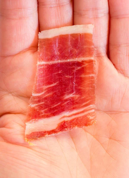 Serrano ham slice and hand — Stock Photo, Image