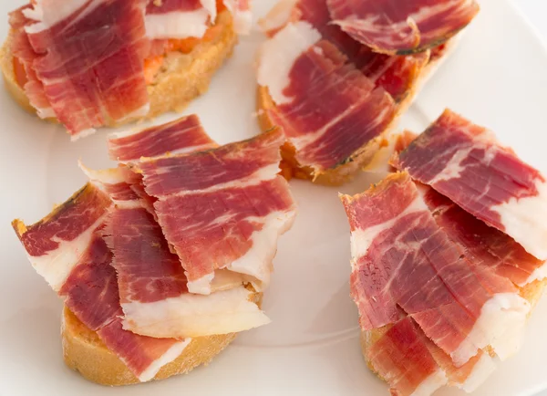 Spanish tapas, ham and tomato — Stock Photo, Image