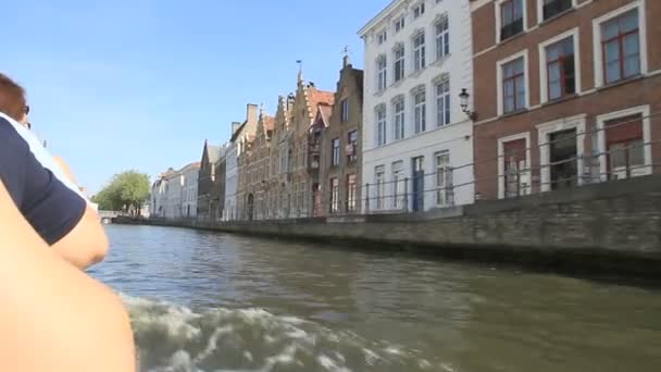 Velejando sobre o canal com casas vintage e ponte em Brugge, Bélgica — Vídeo de Stock