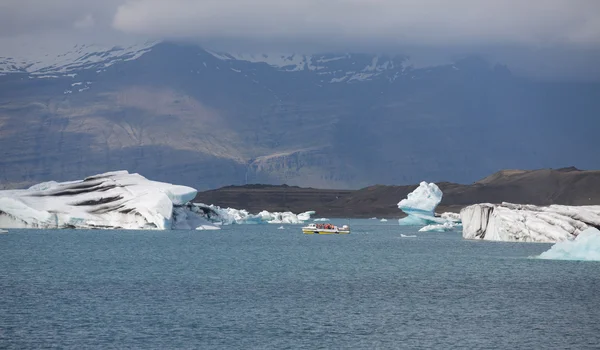 Сині айсберги, лагуна і туристичний човен — стокове фото
