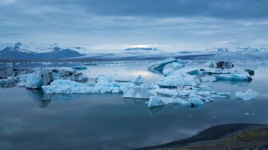 Mavi icebergs geceyarısı güneşi altında yüzen