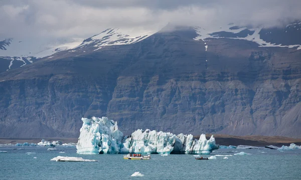 Blauwe ijsbergen, lagune en toeristische boot — Stockfoto