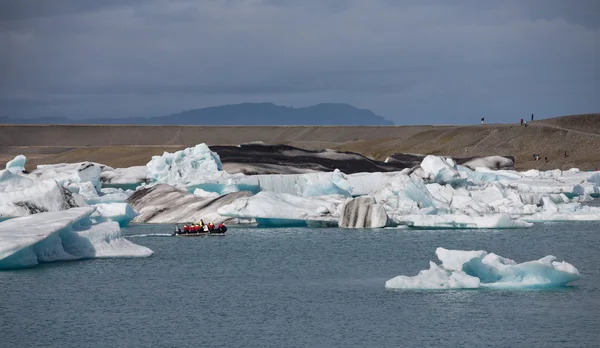 Голубые айсберги, лагуна и туристическая лодка — стоковое фото