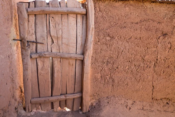 Old wooden door and adobe wall — Stock Photo, Image