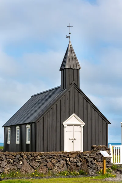 Čelní pohled černý dřevěný kostel proti zatažené obloze v budir, Island — Stock fotografie
