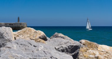 Taş deniz feneri ve yelkenli tekne