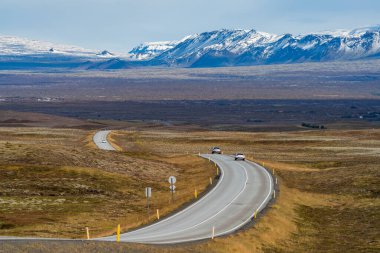 İzlanda 'daki virajlı yolda arabalarla dağlık araziye doğru