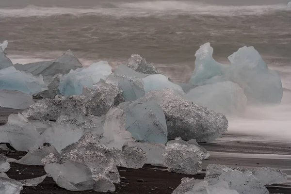 Erstaunliche Eisberge am schwarzen Sandstrand Islands angespült. — Stockfoto