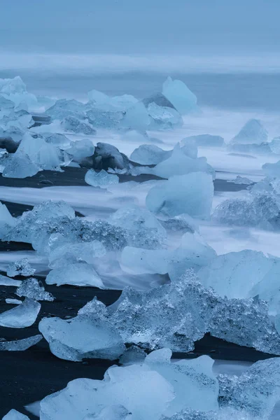 Praia pitoresca com peças de iceberg na praia Diamond perto da lagoa Jokulsarlon, exposição longa — Fotografia de Stock