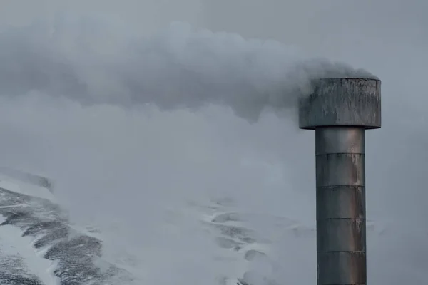 Smokestack savu sarake ja lumen peitossa vuoret — kuvapankkivalokuva