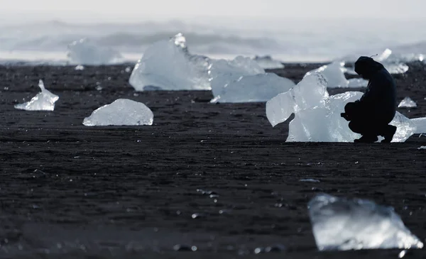 Donker toeristisch silhouet genieten van diamantstrand fotograferen — Stockfoto