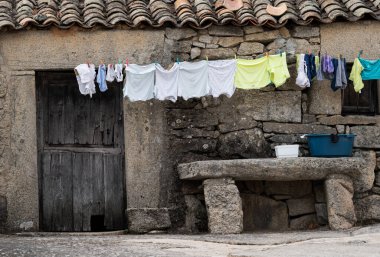 Kurutmak için asılmış elbiselerle antik taş cephe