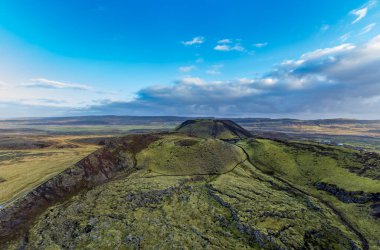 Bulutlu gökyüzünün altında iki volkan krateri.