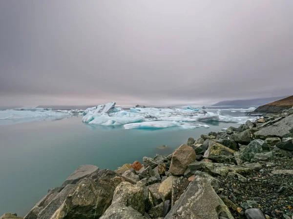 Laguna di ghiaccio e ghiacciaio lunga esposizione, giornata nuvolosa a Jokusarlon — Foto Stock