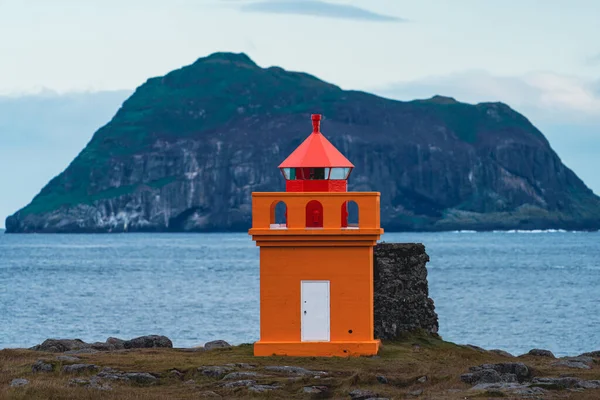 Phare orange avec un énorme îlot en arrière-plan — Photo