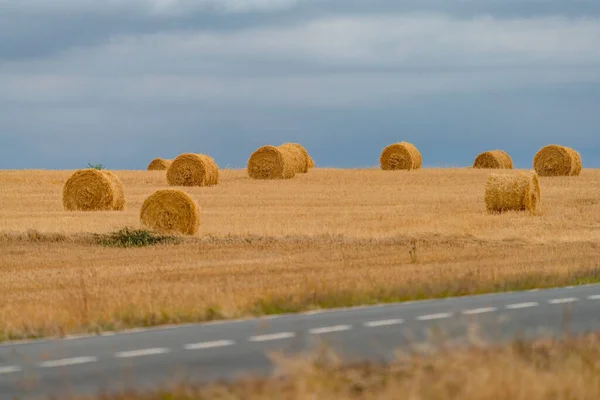 Road and straw balls under the stormy sky — Stock Photo, Image