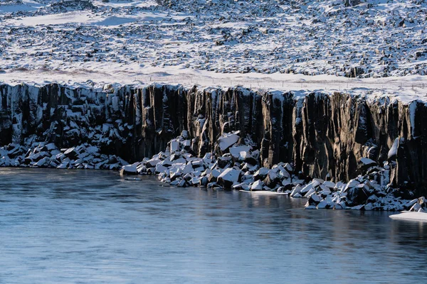 Stenkuber under klipporna med snö — Stockfoto