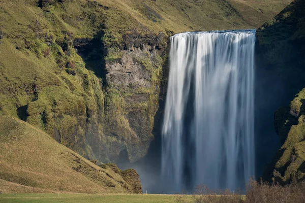 Uzaktaki ünlü Skogafoss şelalesinin uzun pozu. — Stok fotoğraf