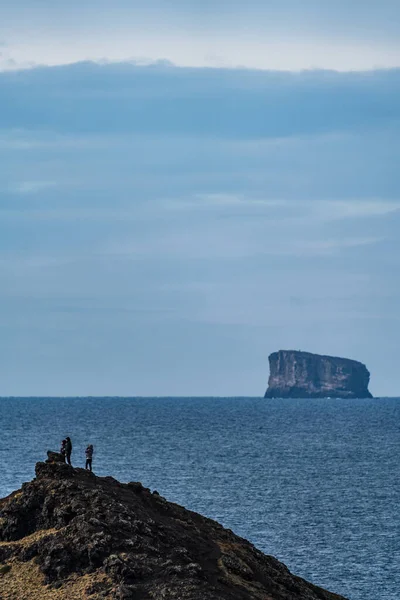 Touristes sur la colline avec un énorme îlot en arrière-plan — Photo