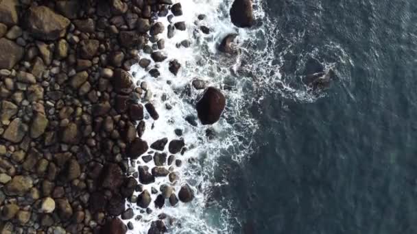 Moviéndose sobre las olas del océano rompiendo la costa con enormes rocas — Vídeos de Stock