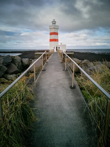 Farol e caminho sob dia nublado e maré baixa — Fotografia de Stock