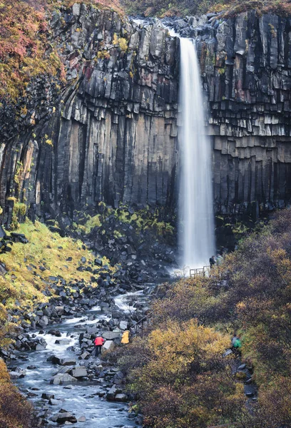 Cachoeira Svartifoss água de seda no parque nacional Skaftafell na Islândia com turistas — Fotografia de Stock