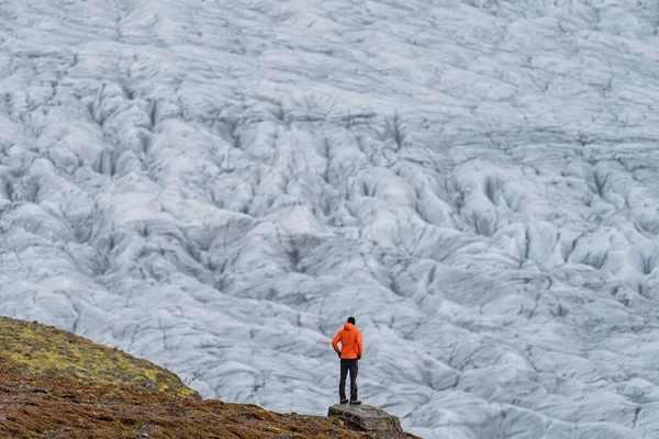 Неузнаваемый турист смотрит на массивный ледник — стоковое фото