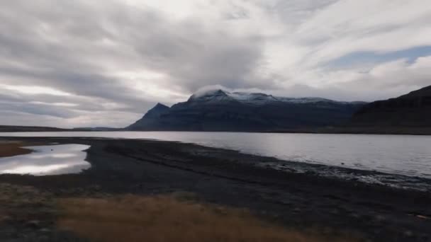 Förare runt fjord med fjällreflektioner — Stockvideo