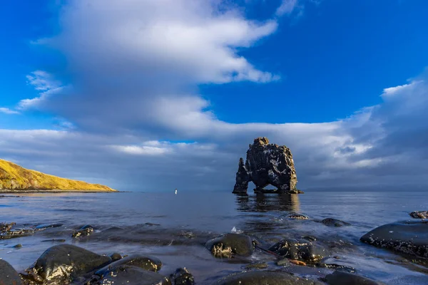 Tourist approaching Hvitserkur boulder and rounded rocks — Stock Photo, Image