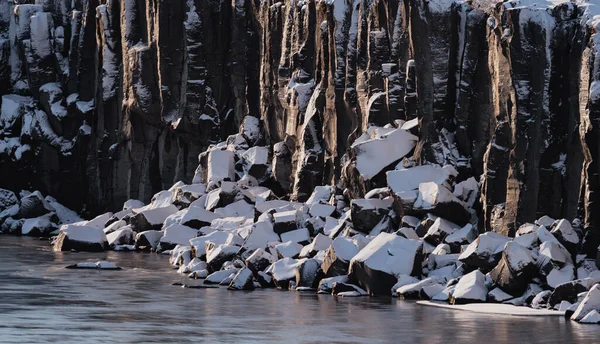 Kostka skály na břehu řeky pokryté sněhem, detailní záběr — Stock fotografie