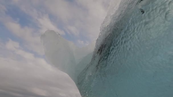 Głęboka niebieska góra lodowa pod zachmurzonym niebem — Wideo stockowe