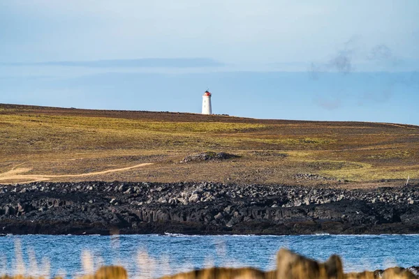 Gömd fyr över det vulkaniska landskapet och molnig himmel — Stockfoto