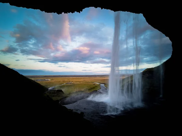 Uvnitř Seljalandsfoss vodopád za úsvitu na Islandu — Stock fotografie