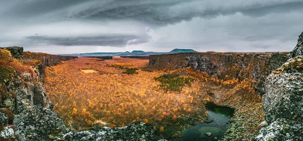 Muren rondom Asbyrgi canyon met sinaasappelbomen in de herfst met bliksem — Stockfoto