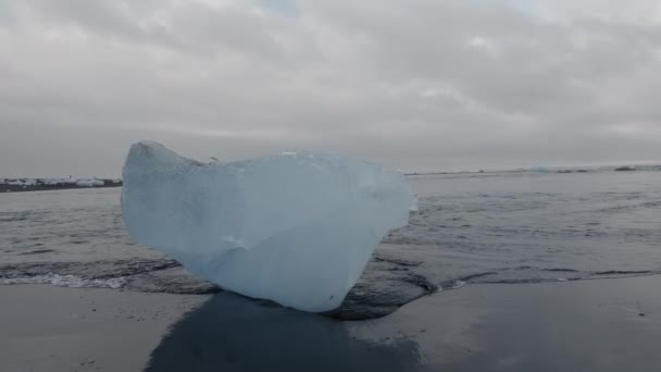 Masivo iceberg sobre la arena negra en lento-mo — Vídeos de Stock