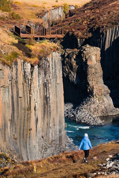 Spectacular basaltic columns and river canyon with blurred tourist — Stock Photo, Image