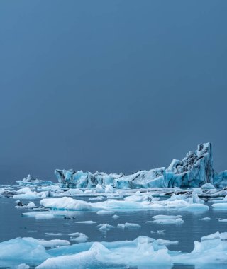 Jokulsarlon gölü üzerindeki devasa buzdağı açık gökyüzü altında metin için
