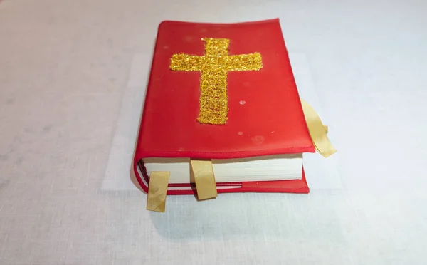 Antik nedbrunnen röd bibel bok med kors över linnet — Stockfoto