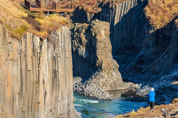 Basaltic columns and river canyon with blurred tourist — Stock Photo, Image