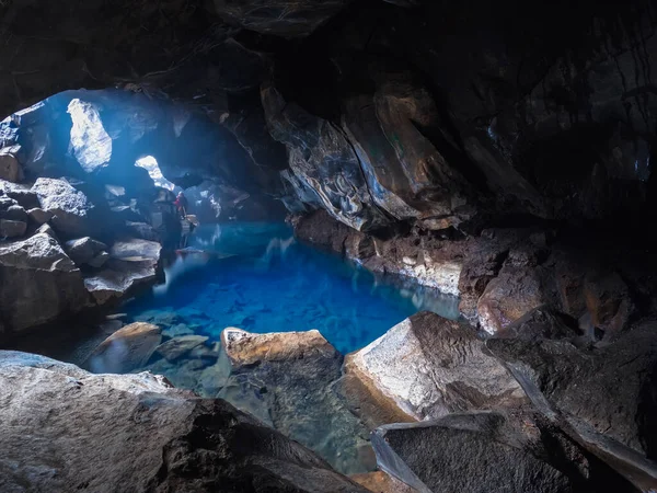 Hluboké modré jezero uvnitř jeskyně s fotografem — Stock fotografie