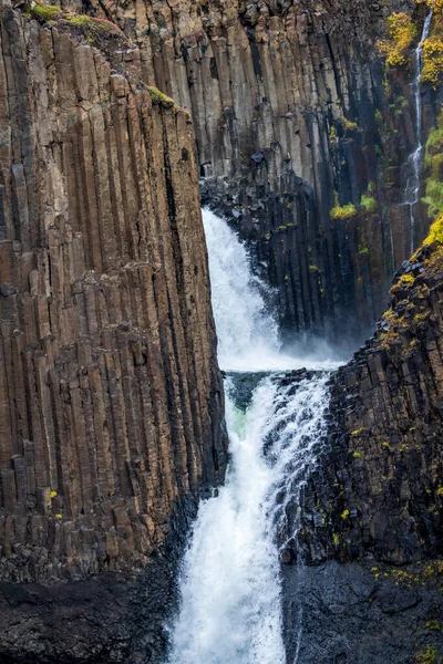 Narrow waterfall with basaltic columns, long shot — ストック写真