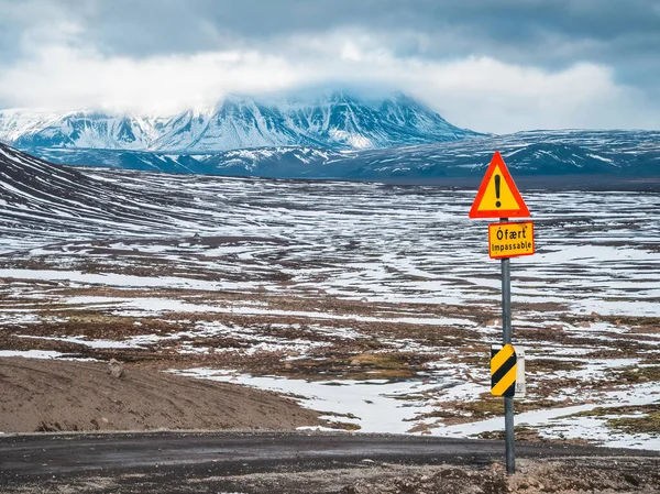 Estrada remota para terras altas com sinais de perigo intransitáveis — Fotografia de Stock