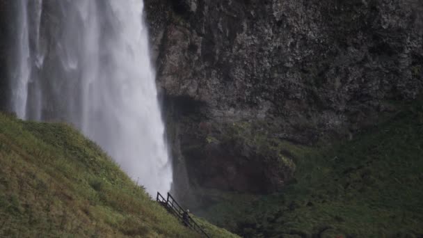 Seljalandsfoss şelalesi yavaş çekimde tanınmayan bir turistle — Stok video
