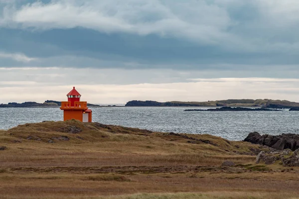 Oddalona pomarańczowa nowoczesna latarnia morska na wybrzeżu — Zdjęcie stockowe