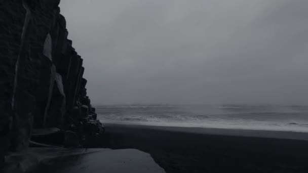 Буря над базальтовим пляжем з хмарним небом, хиткою камерою — стокове відео