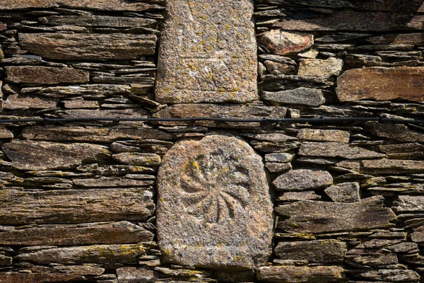 Old carved stones used as infill in the wall of a house — Stock fotografie
