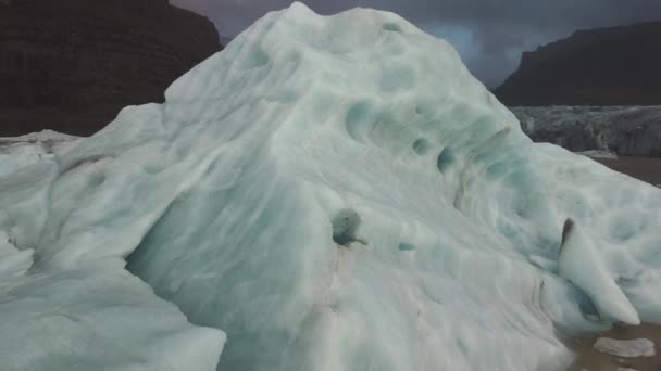 Flying away from iceberg with hole and glacier tongue — стоковое видео